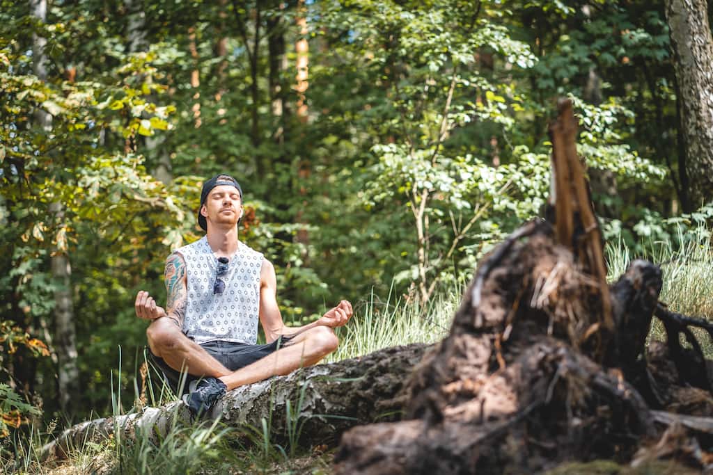 man meditating in the forest