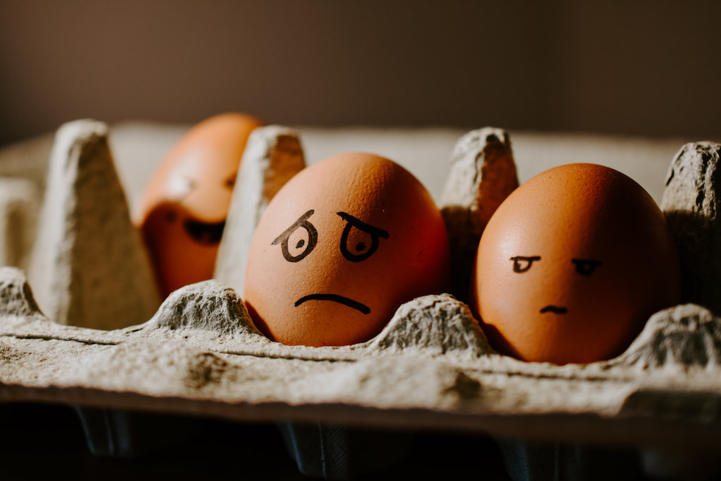 image of two eggs with faces drawn, one looks worried, and the other angry, evoking a work environment where second hand stress is active