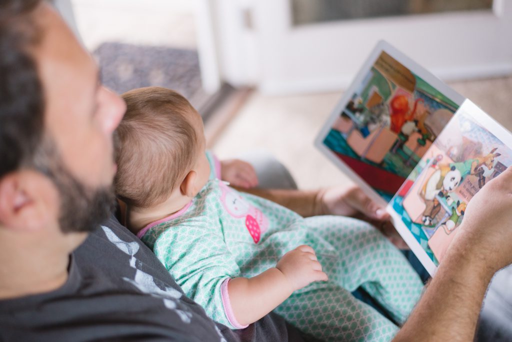 dad reading a book to his baby