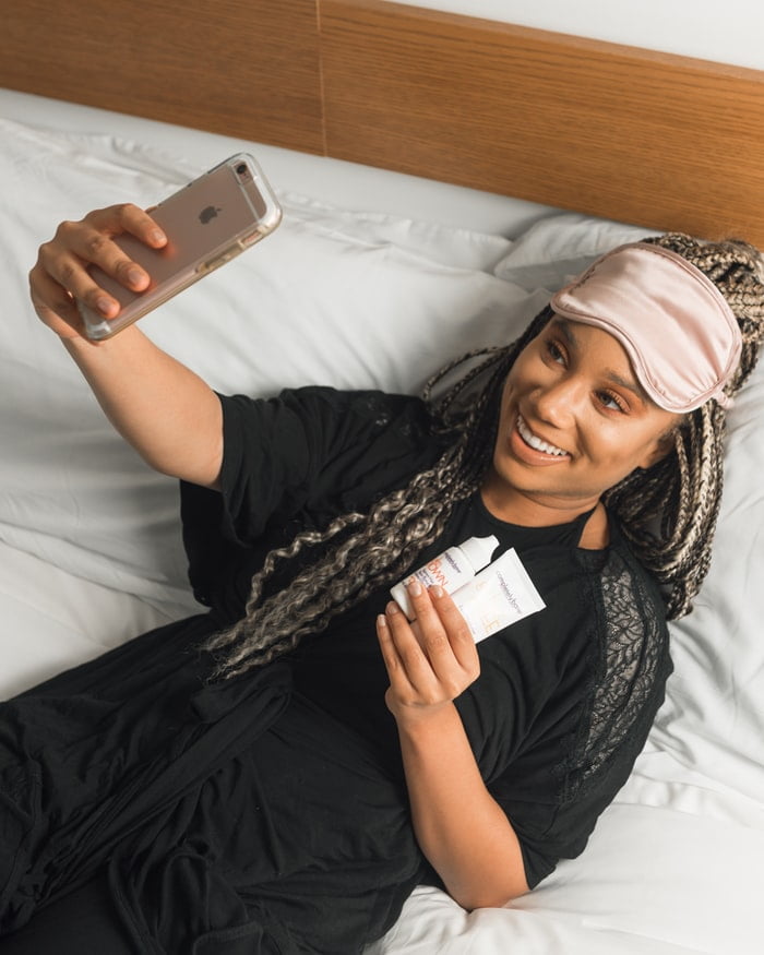 woman taking a selfie with her ıphone while smiling