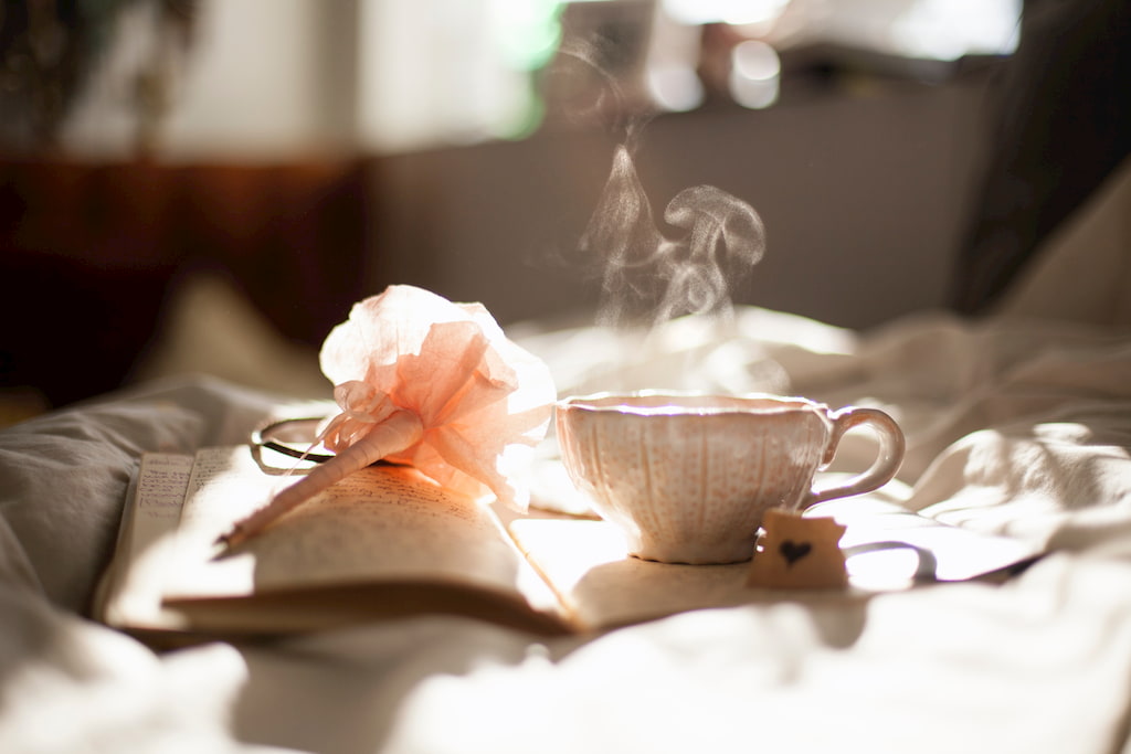 book flower and cup on white sheet