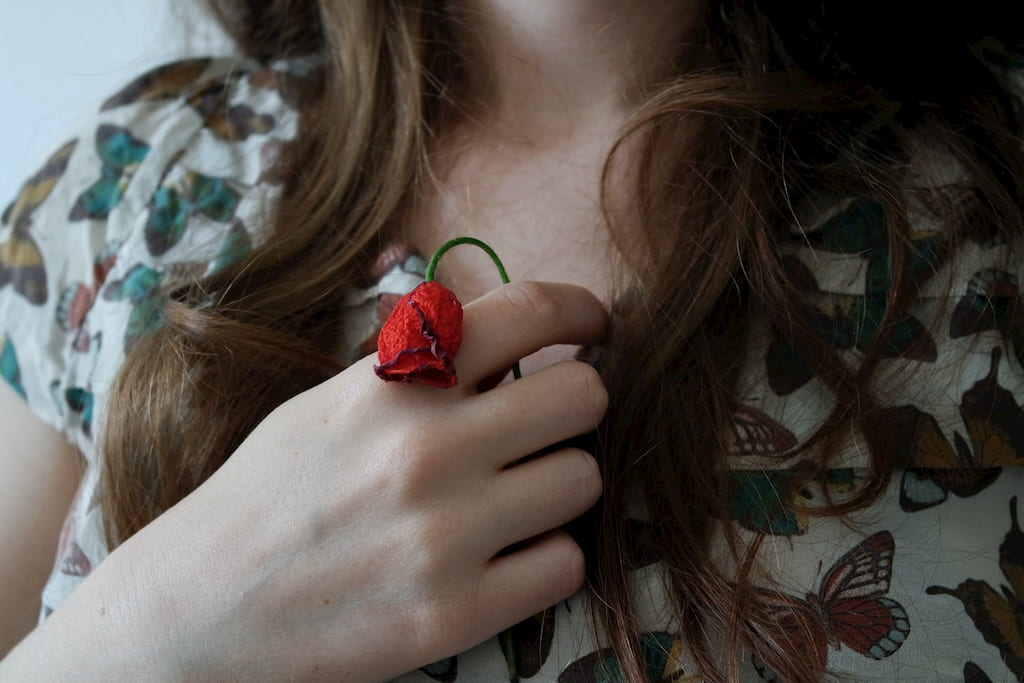 woman holding red flower