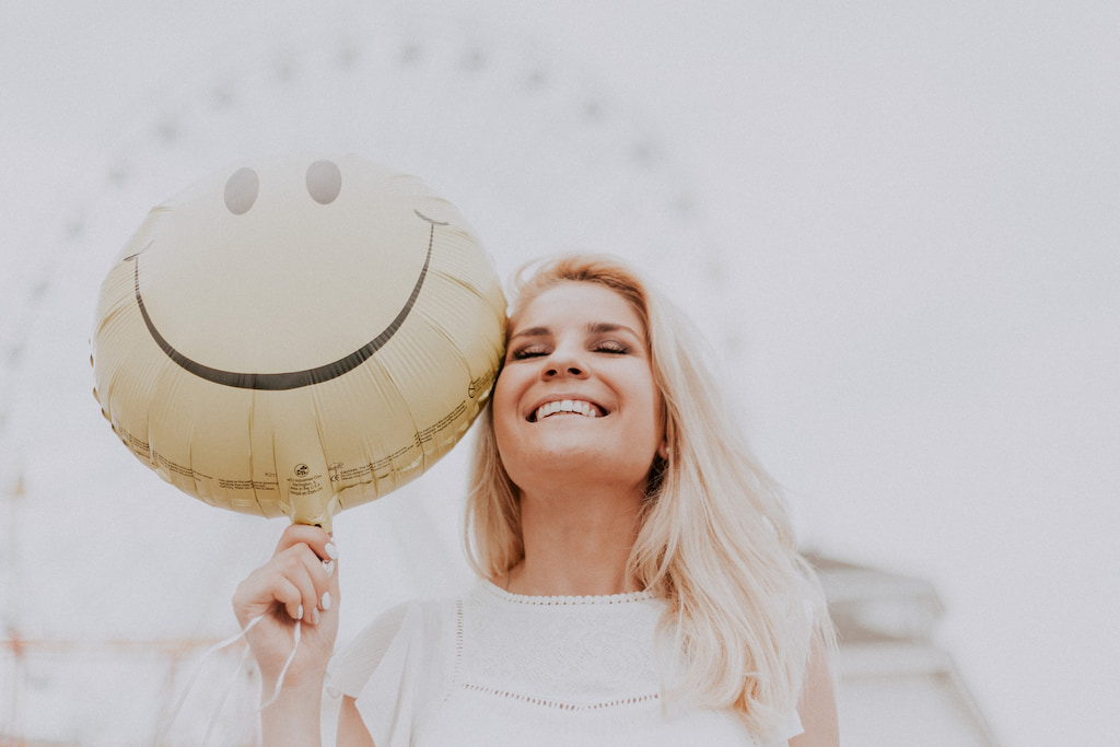 woman, smiles with a smiley baloon