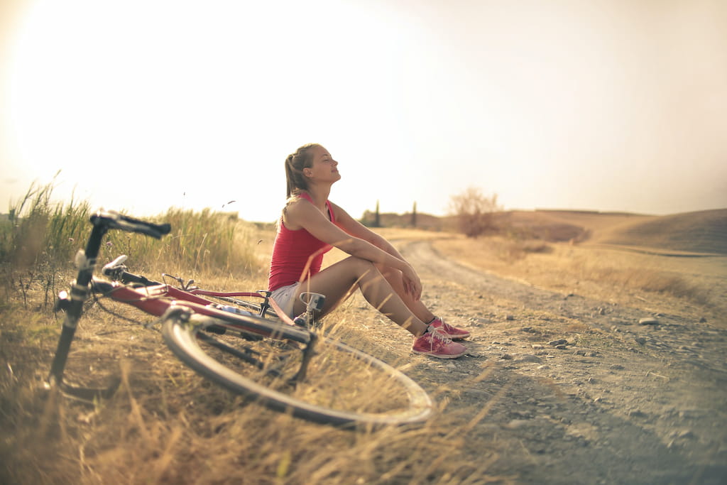 women with bicycle sititng on the ground