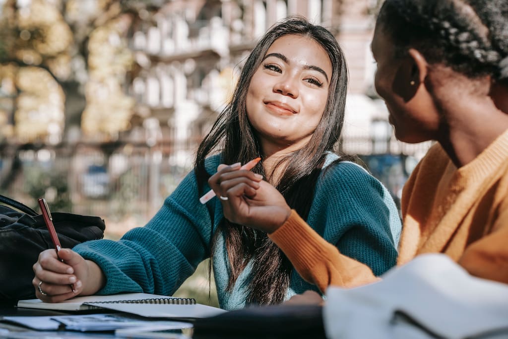 a student is smiling to her friend