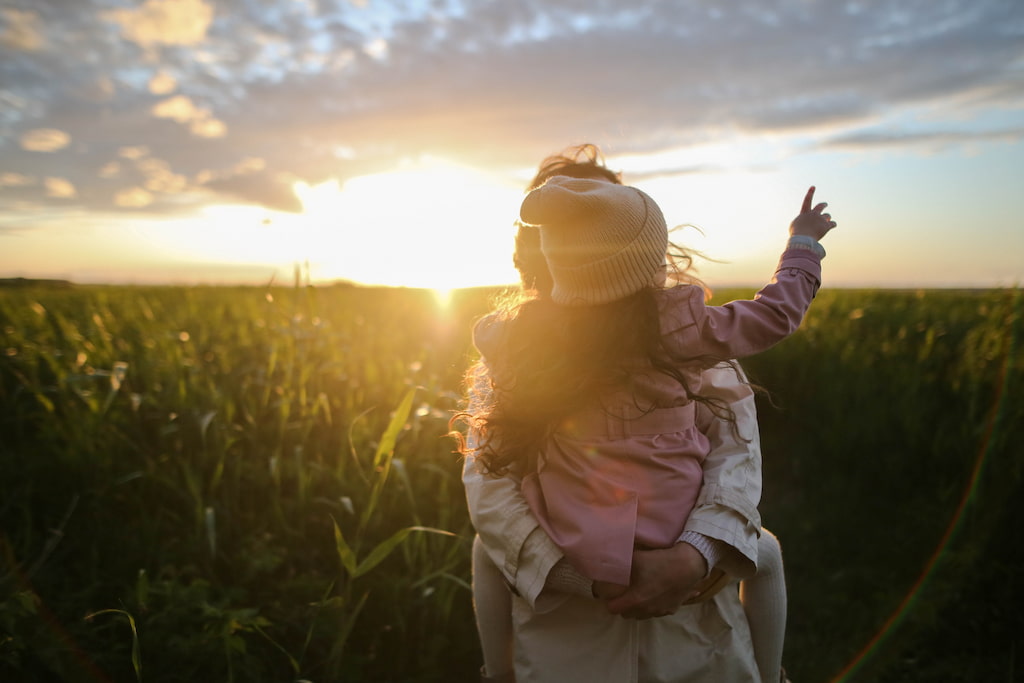 mother and her child are walking mindfully on the grass 