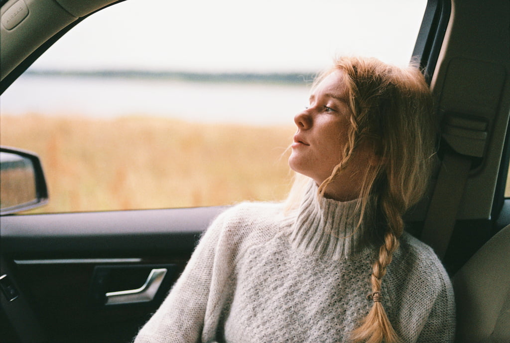 thoughtful blonde woman in the car