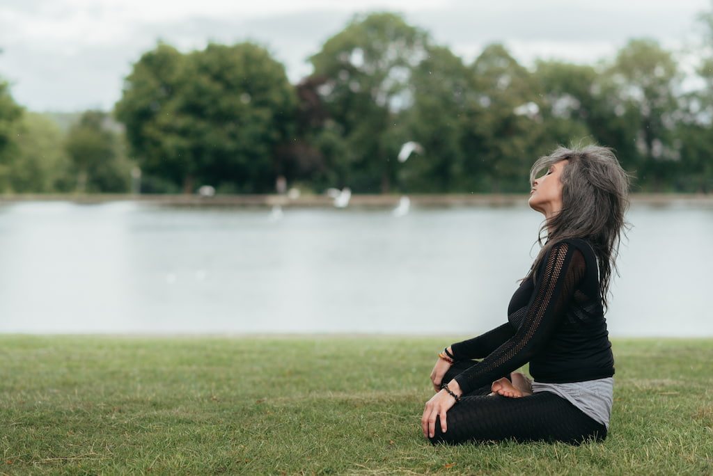 woman is meditating by the sea