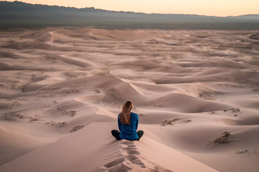 woman meditating in the desert
