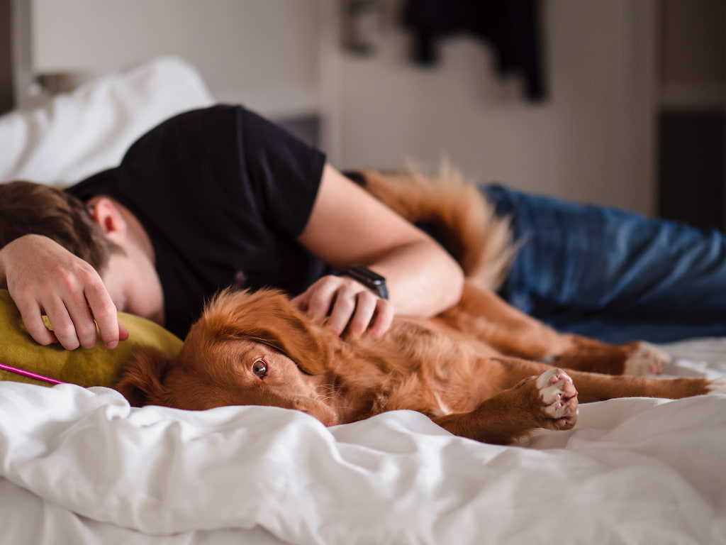 man sleeping with his dog