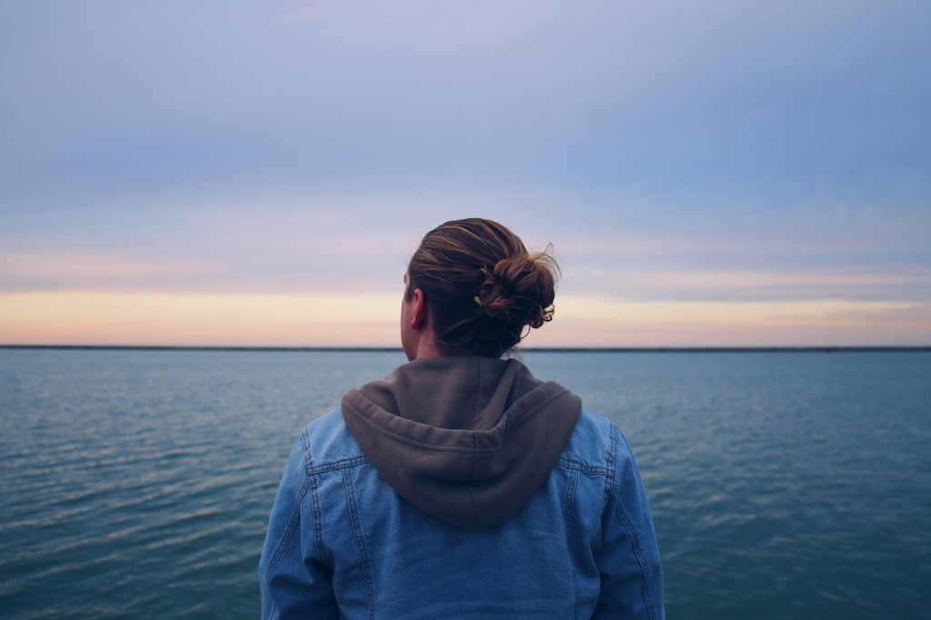 person wearing sweatshirt near sea