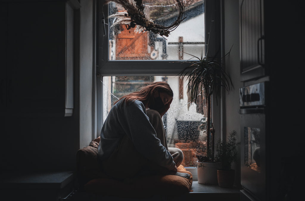 woman sitting home with a mask